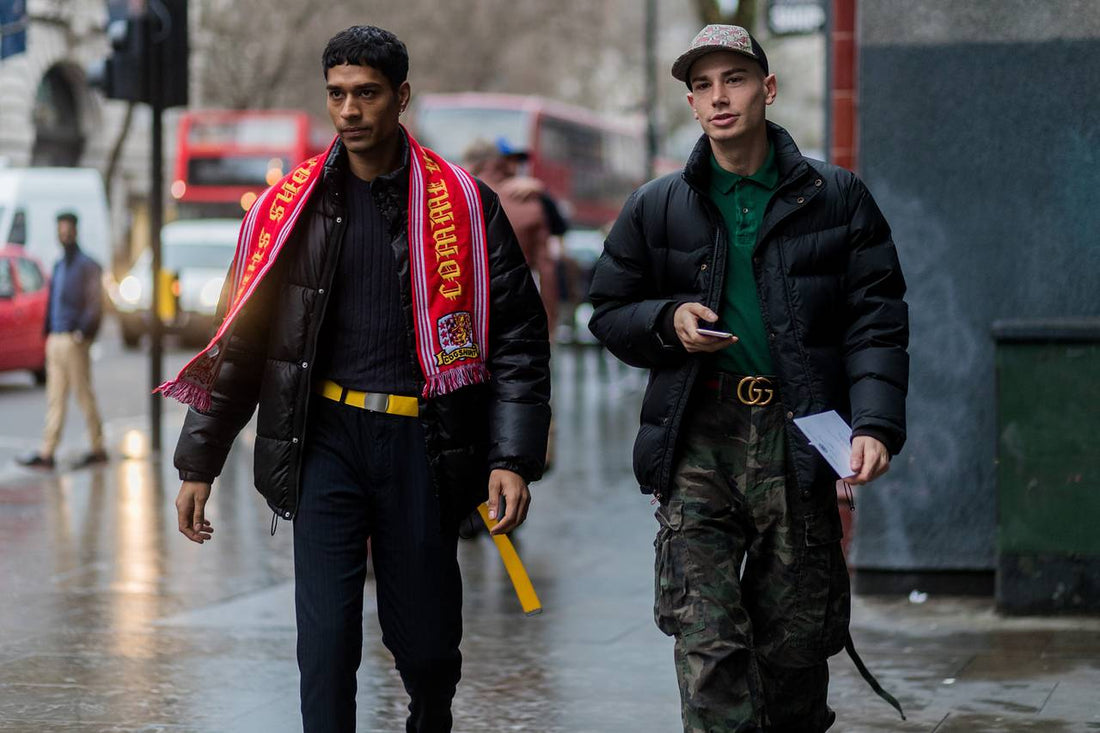 A model wearing a vintage football jersey paired with an oversized jacket and sneakers, blending retro football and streetwear fashion.